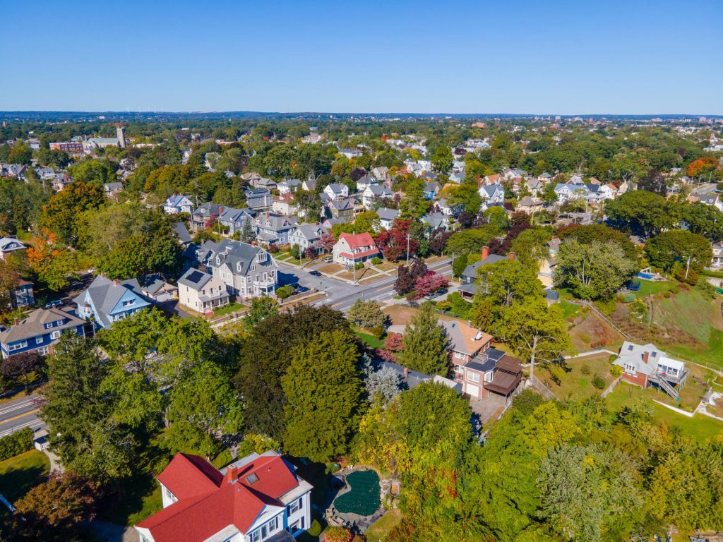 Aerial view of residential area with trees and blue sky